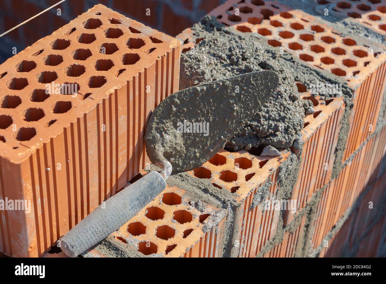 Spachtel und Zementmörtel, rotes Ziegelmauerwerk, Baukonzept Stockfoto