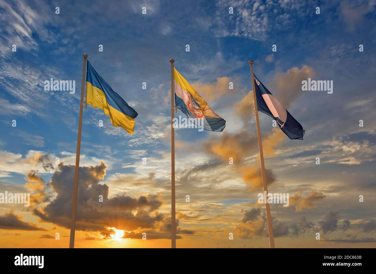 Flaggen der Ukraine, Tschernomorsk Stadt und Blaue Flagge 2020 winken gegen dramatischen Sonnenuntergang Stockfoto