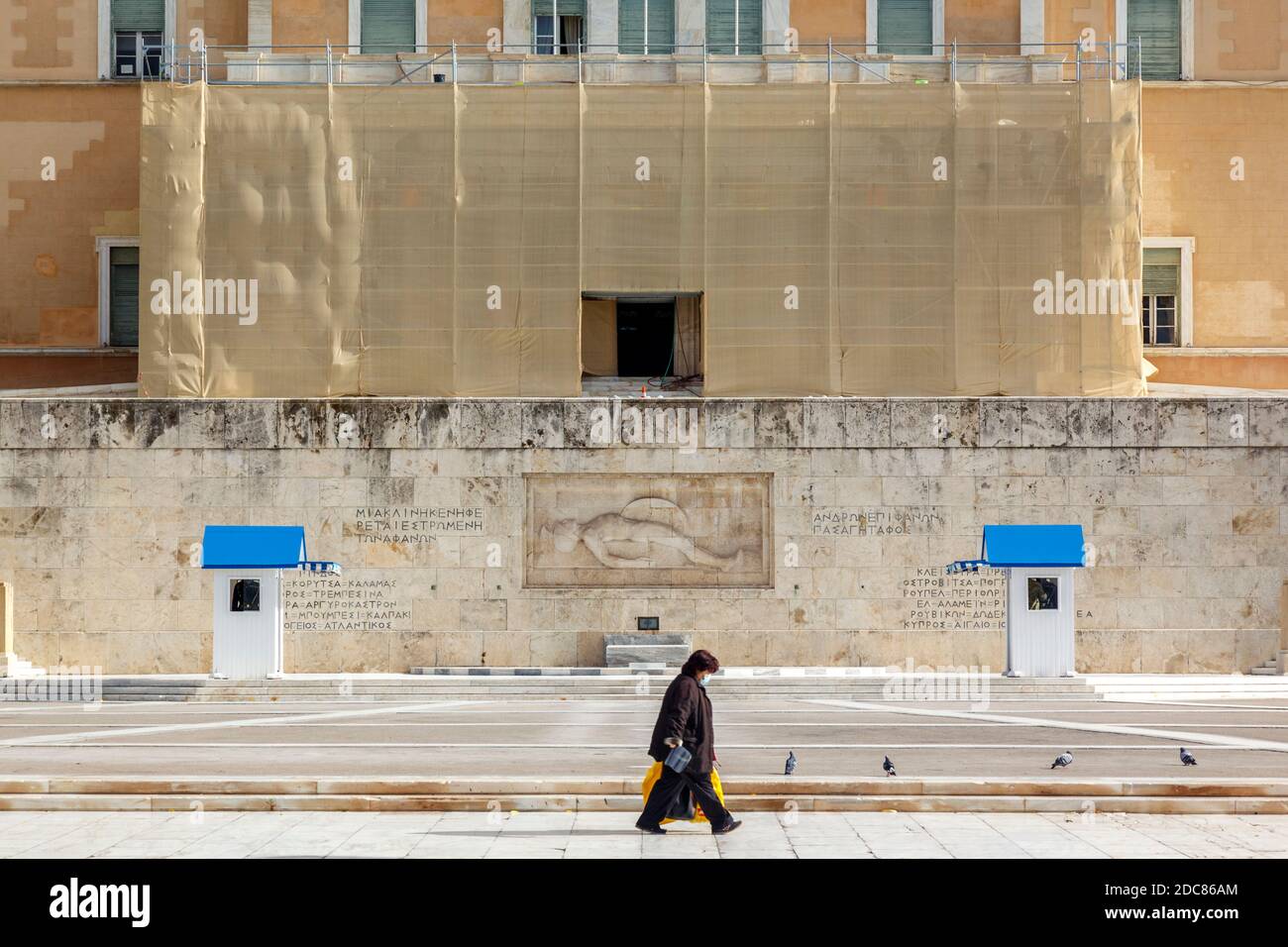 Eine Frau, die ohne Verkehr am griechischen Parlament vorbeikommt Überhaupt aufgrund von Verkehrsbeschränkungen des Coronavirus-Ausbruchs Stockfoto