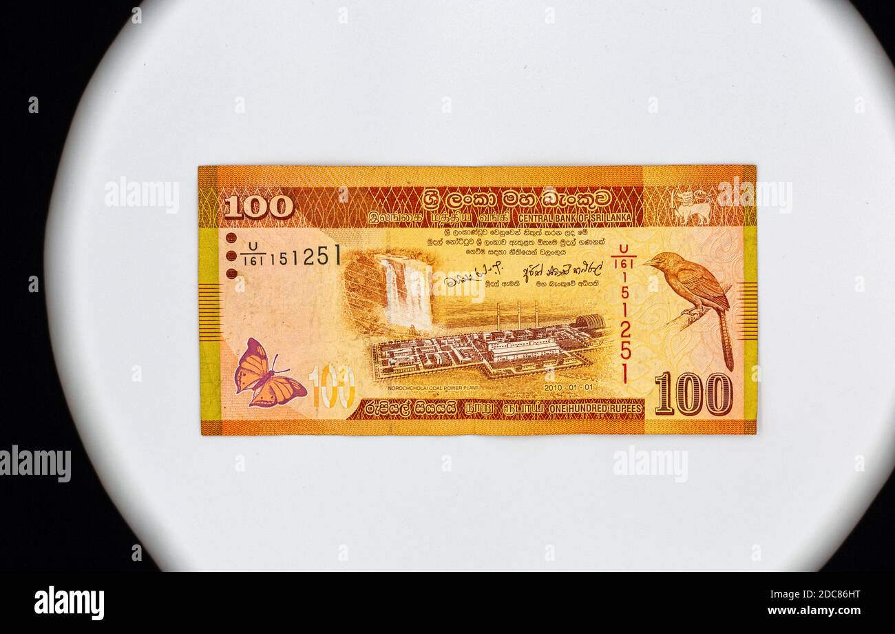 100 Sri Lanka Rupie umgekehrte Banknote Nahaufnahme mit Kopierraum. Norochcholai Kohlekraftwerk Projekt und Laxapana Wasserfall, Sri Lanka orange bil Stockfoto