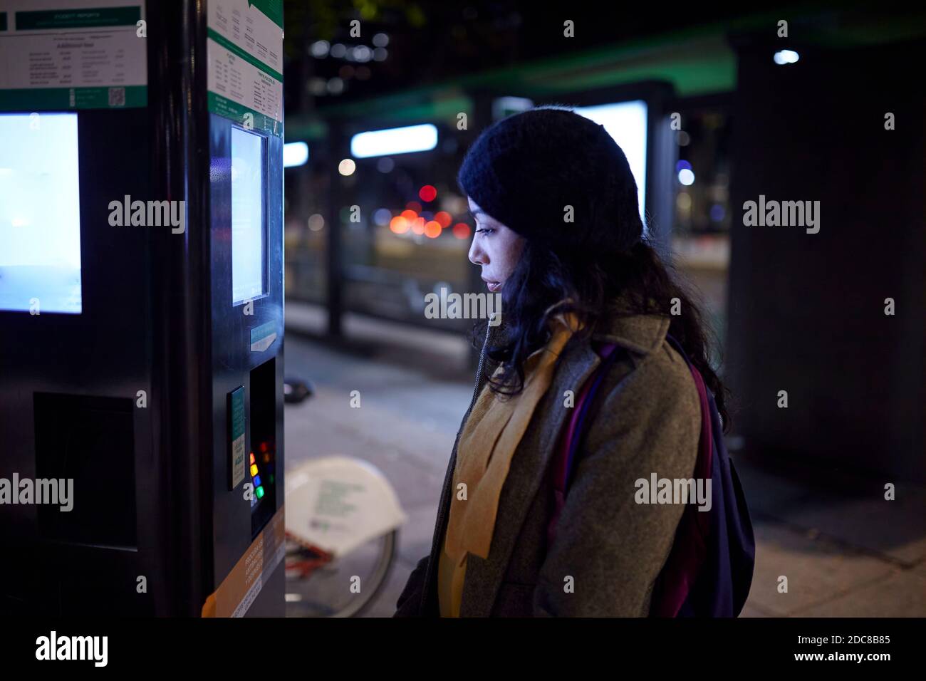 Frau benutzt Geldautomaten in der Nacht Stockfoto