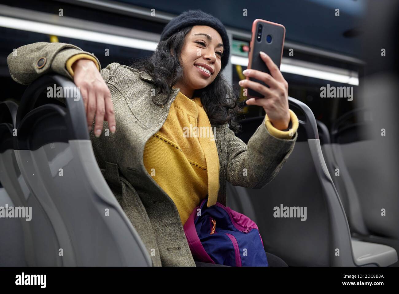 Frau sitzt und mit seinem Handy in einem öffentlichen Bus Nachts Stockfoto