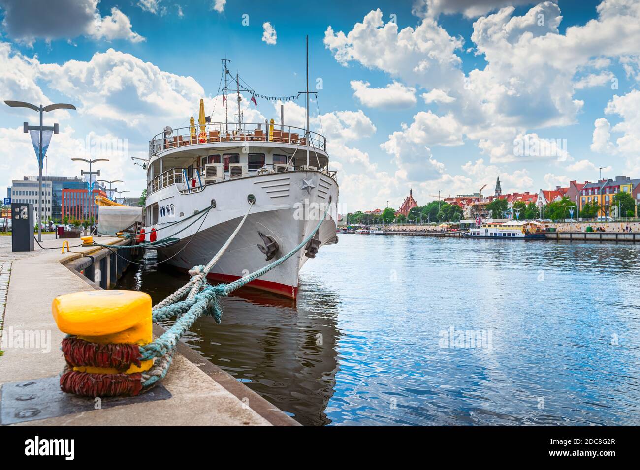 Großes Boot, das am Zollkai angedockt oder festgemacht ist, Blick auf die Promenade und die Boulevards auf der Einschiffung des Flusses Odra mit der Altstadt im Hintergrund in Stettin, Polen Stockfoto