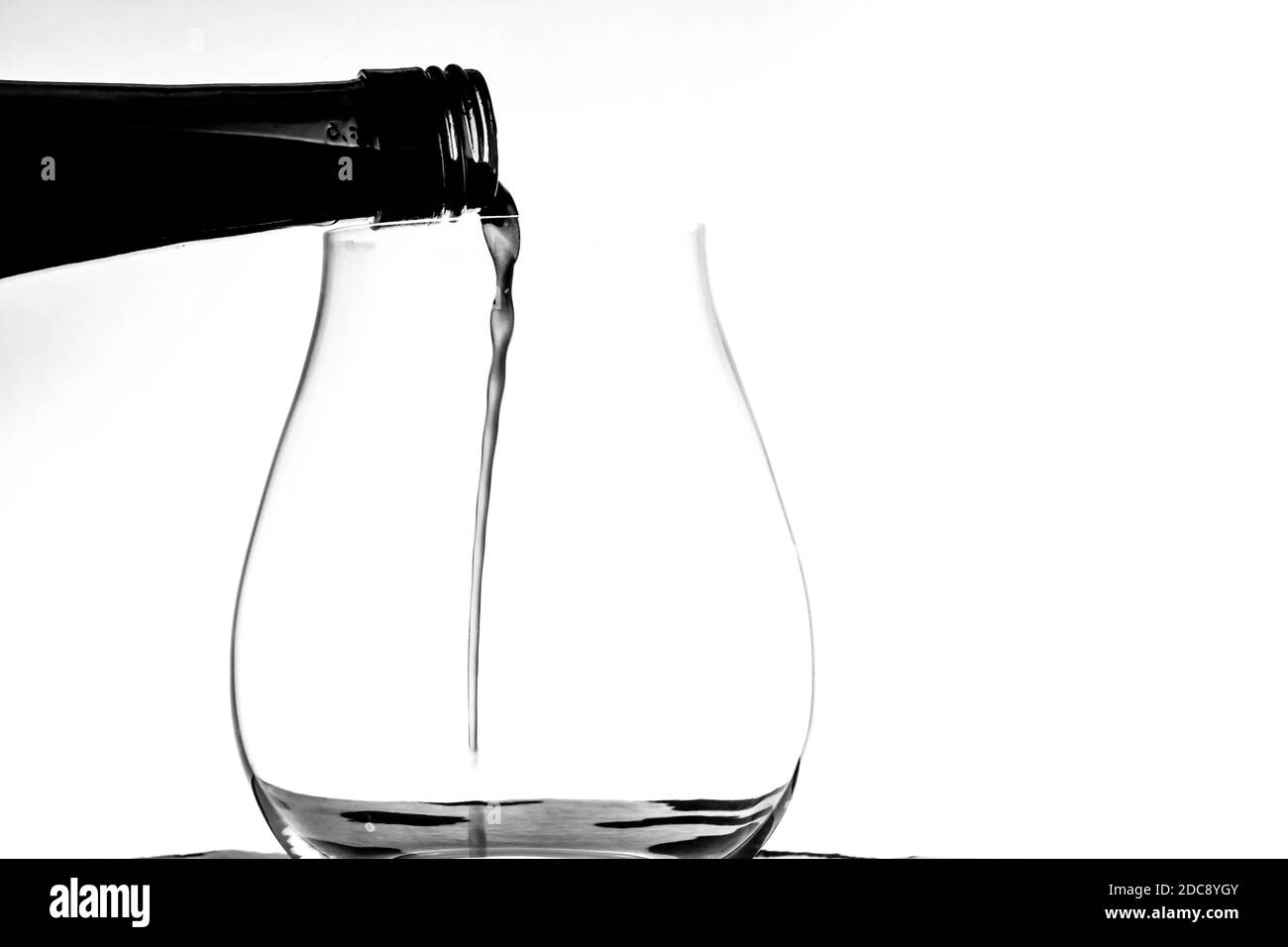 Rotwein Gießen in einem Weinglas Stockfoto