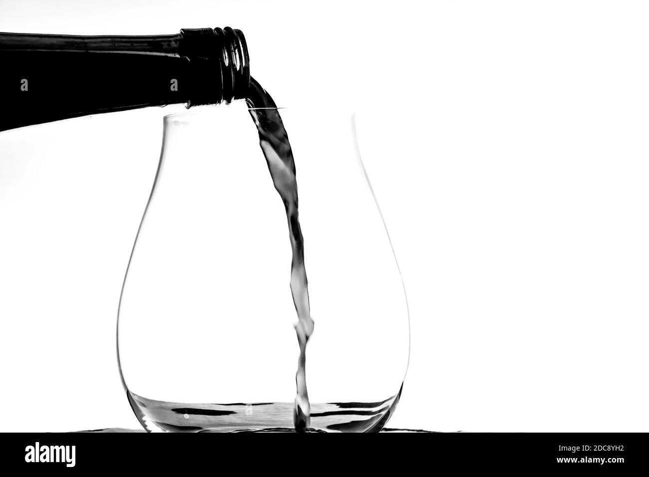 Rotwein Gießen in einem Weinglas Stockfoto