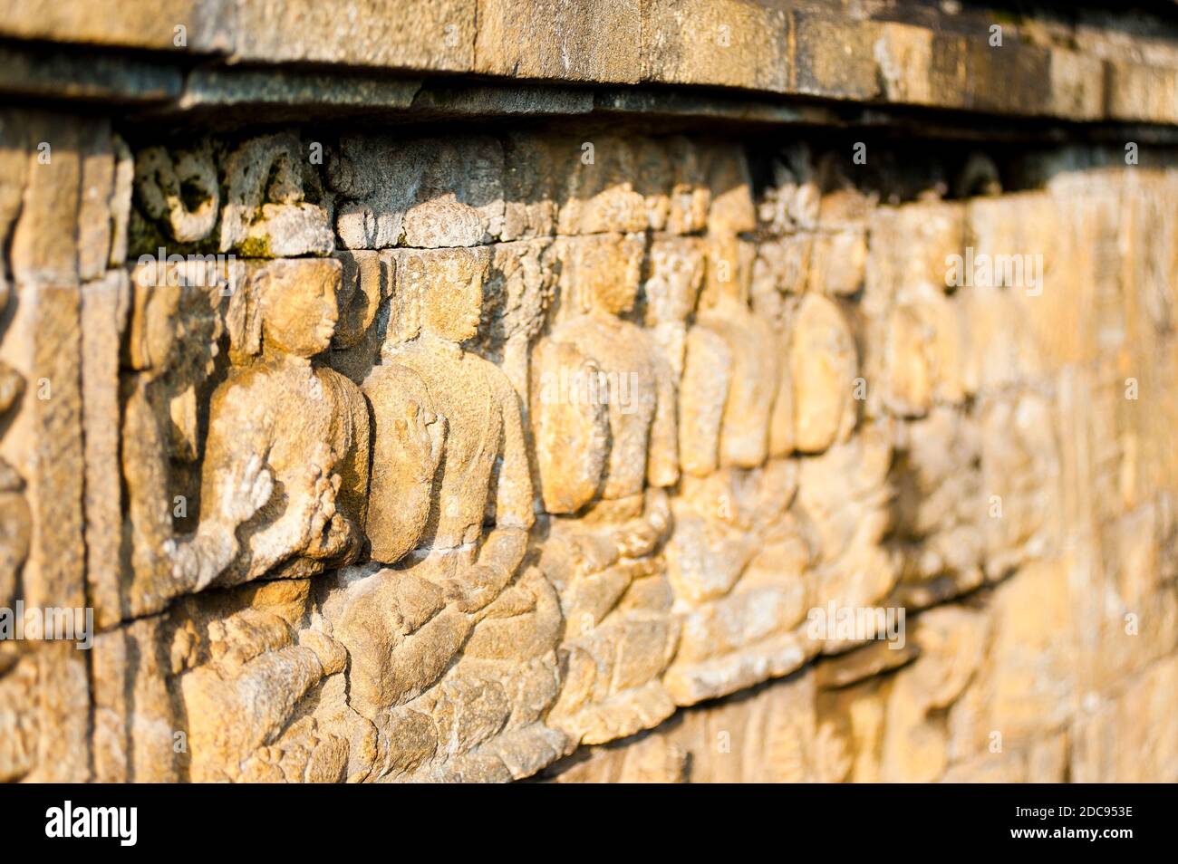 Nahaufnahme Foto des Details der Steinbas Reliefschnitzereien, die die Wände des Borobudur-Tempels umschließen, Yogyakarta, Java, Indonesien, Asien, Hintergrund mit Kopierraum Stockfoto