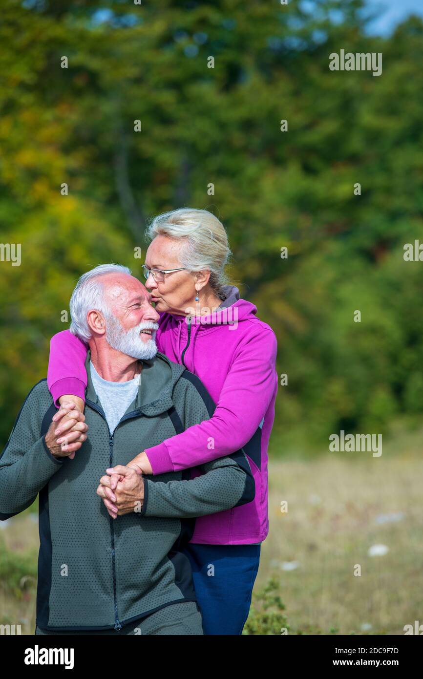 Glückliches Seniorenpaar lächelt im Freien in der Natur. Großeltern, Herbst. Stockfoto