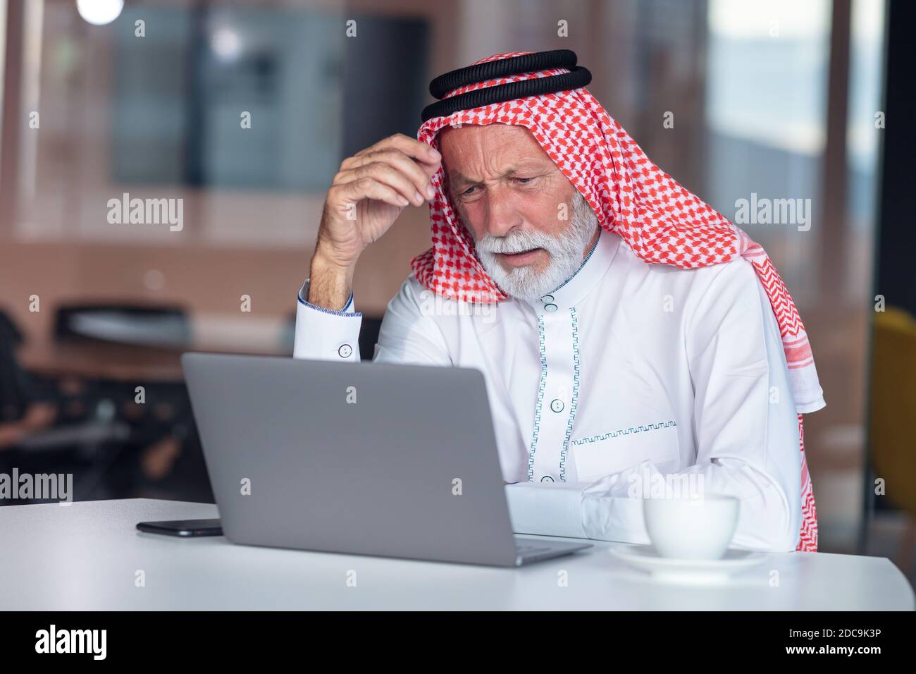 Arabischer Geschäftsmann ist langweilig im modernen Büro. Müde. Stockfoto