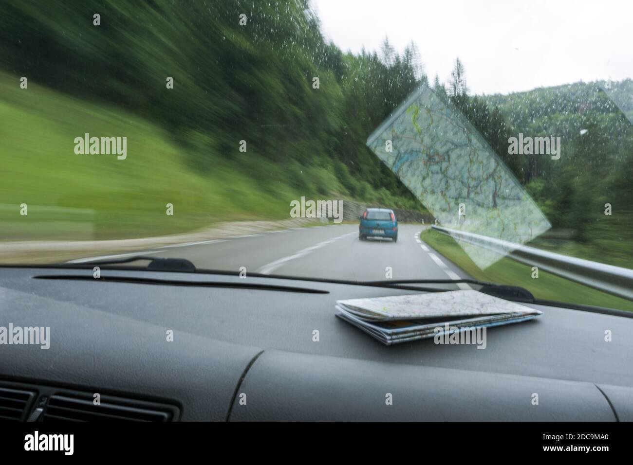 Blick außerhalb der Windschutzscheibe des fahrenden Autos mit Straßenkarte auf Dashboard Stockfoto