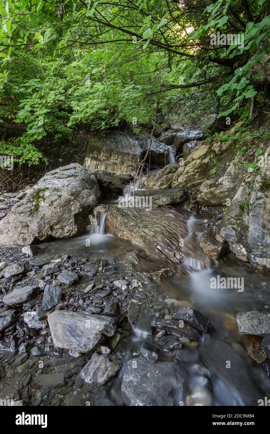 Wunderschöner klarer Wasserbach in den französischen alpen mit Felsen Stockfoto