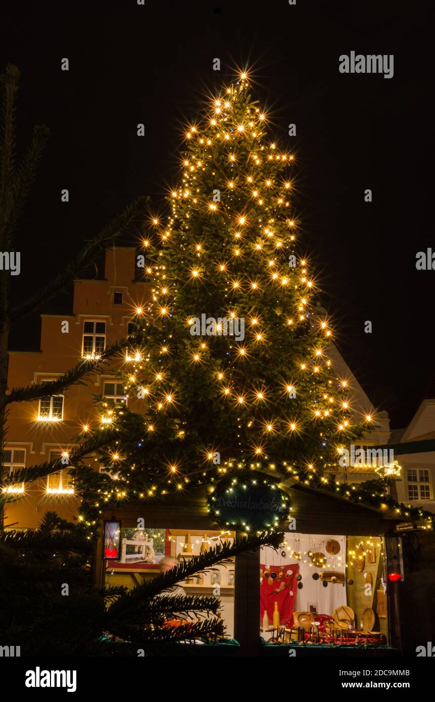 Beleuchteter weihnachtsbaum auf dem deutschen weihnachtsmarkt mit Verkaufsstand Stockfoto
