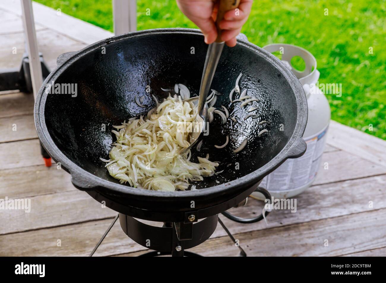 Braten Zwiebel in Kessel auf Feuer im Freien für asiatische Gericht. Stockfoto