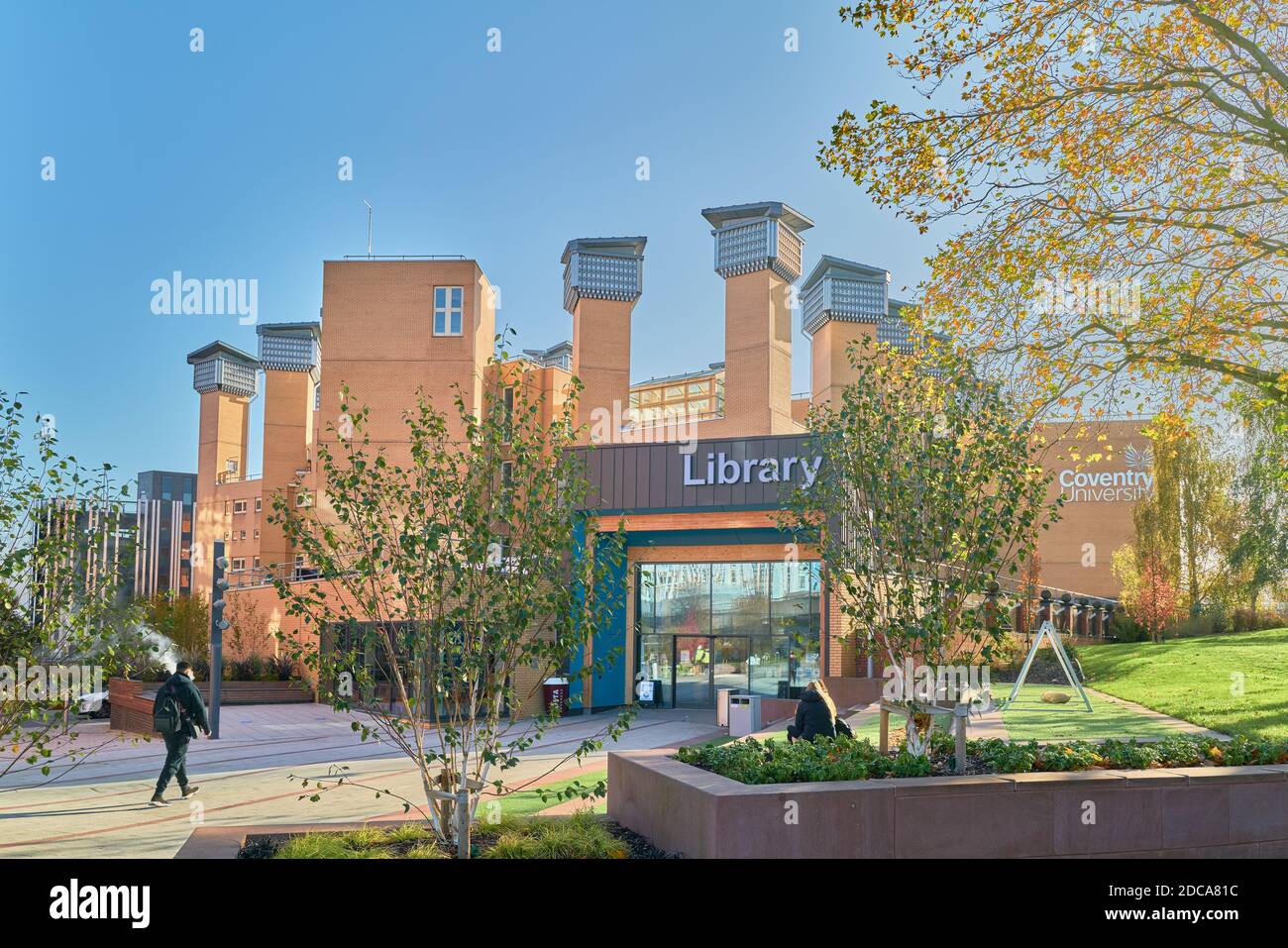Ein Student geht an einem sonnigen Herbsttag zum Eingang der Lanchester Bibliothek, uinversity of Coventry, England. Stockfoto
