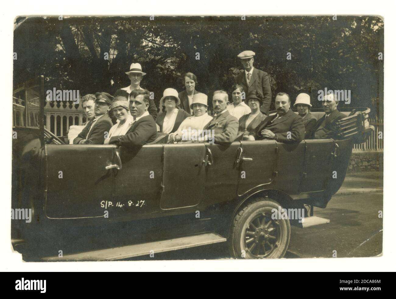 Originalpostkarte aus den 1920er Jahren eines Charabanc-Ausflugs, komplett mit Chauffeur mit Mütze. Die Frauen tragen Cloche Hüte modisch zu der Zeit, datiert 14 Aug 1927 auf der Vorderseite. Albert Smith Ltd., Jersey, Großbritannien Stockfoto