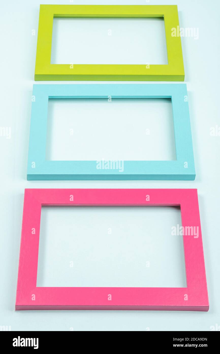 Kreatives Layout aus drei hellen farbigen Rahmen auf blauem Hintergrund. Flat Lay Draufsicht Copy Space Mockup. Stockfoto