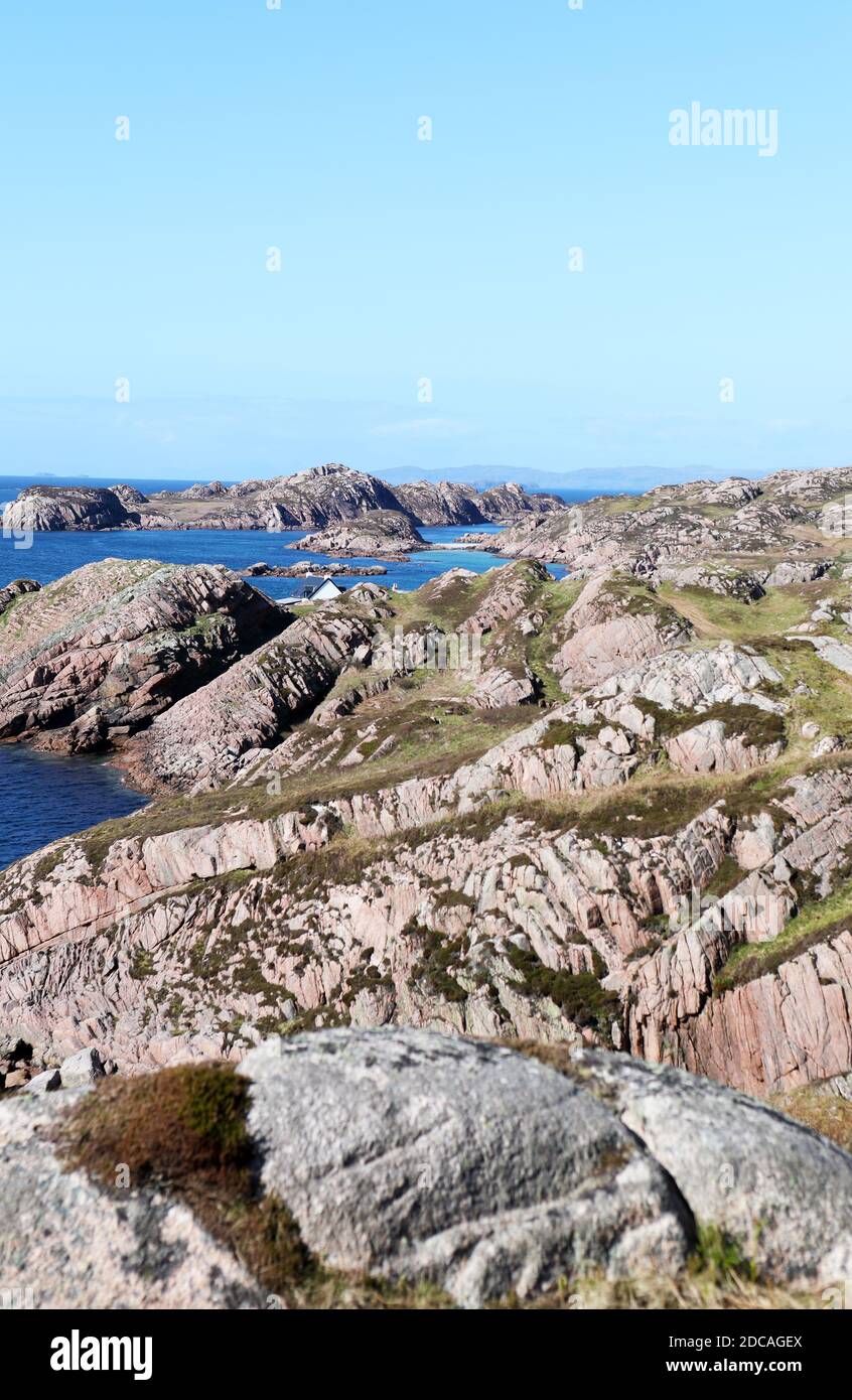 Rosafarbene Granitküste in Richtung Bull Hole auf der Isle Von Mull in den inneren Hebriden von Schottland mit Eilean nam Ban trennte sich vom Festland Stockfoto