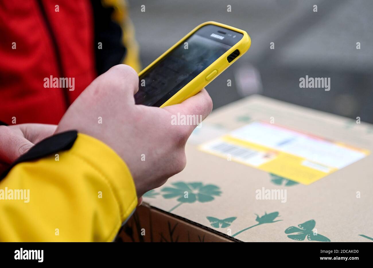 Berlin, Deutschland. November 2020. Ein Mitarbeiter von DHL scannt ein Paket. An mehreren Berliner Standorten stehen die Busse Bürgern als DHL Paketshops zur Verfügung. Quelle: Britta Pedersen/dpa-Zentralbild/dpa/Alamy Live News Stockfoto