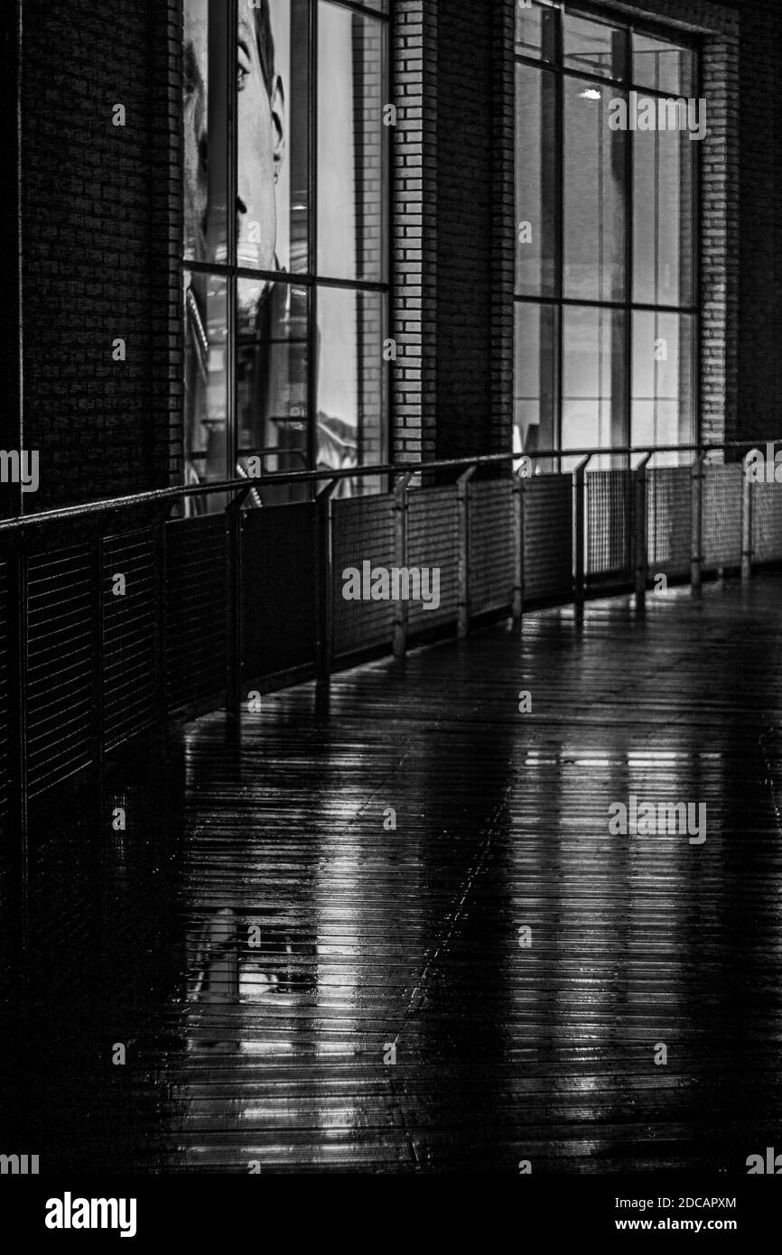 Schwarz-weiß, kontrastreiche und vertikale Aufnahme von regnerischen Abend am Gebäude. Stockfoto