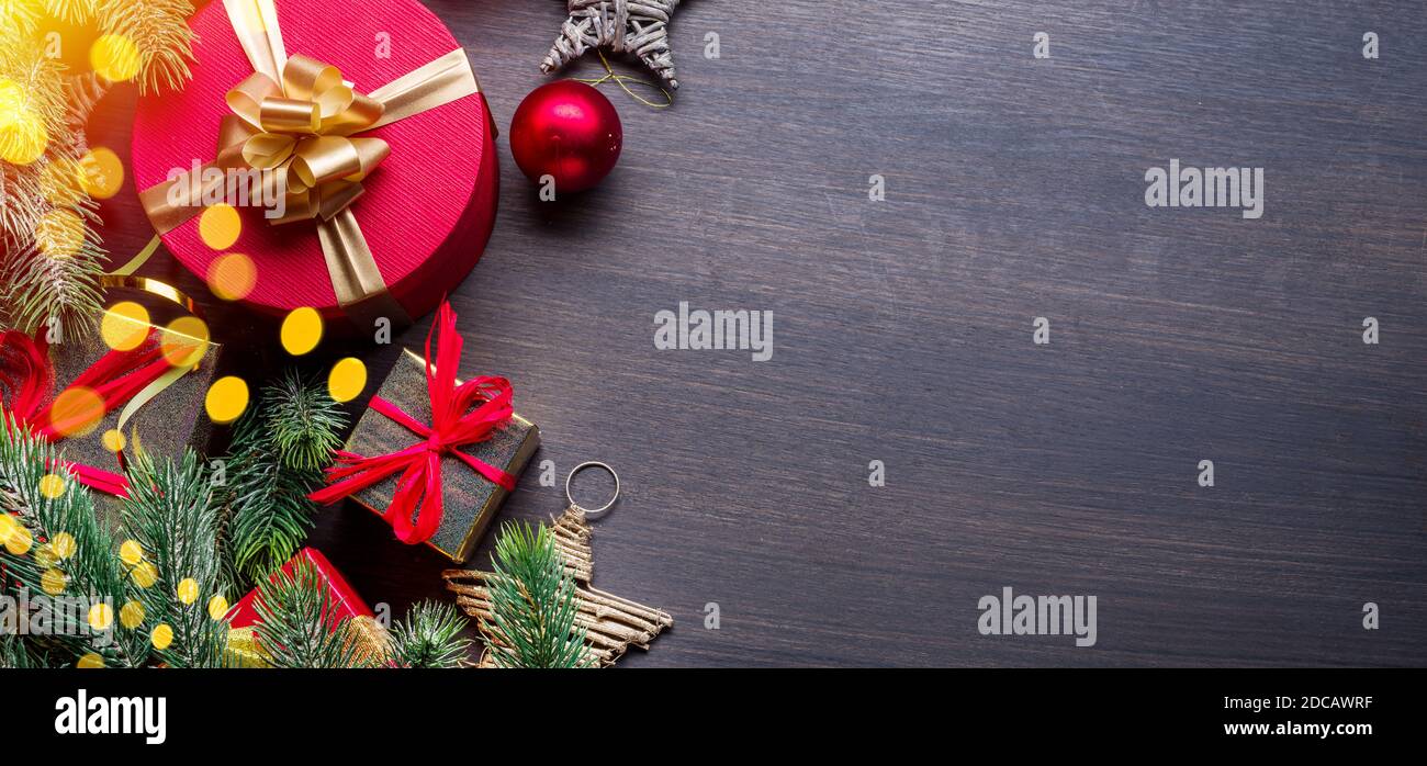 Weihnachtsdekoration, Geschenkschachteln und verschwommene Lichter auf dunklem Holztisch. Weihnachten oder Silvester Hintergrund zeigt den Zauber der Weihnachtsferien Stockfoto