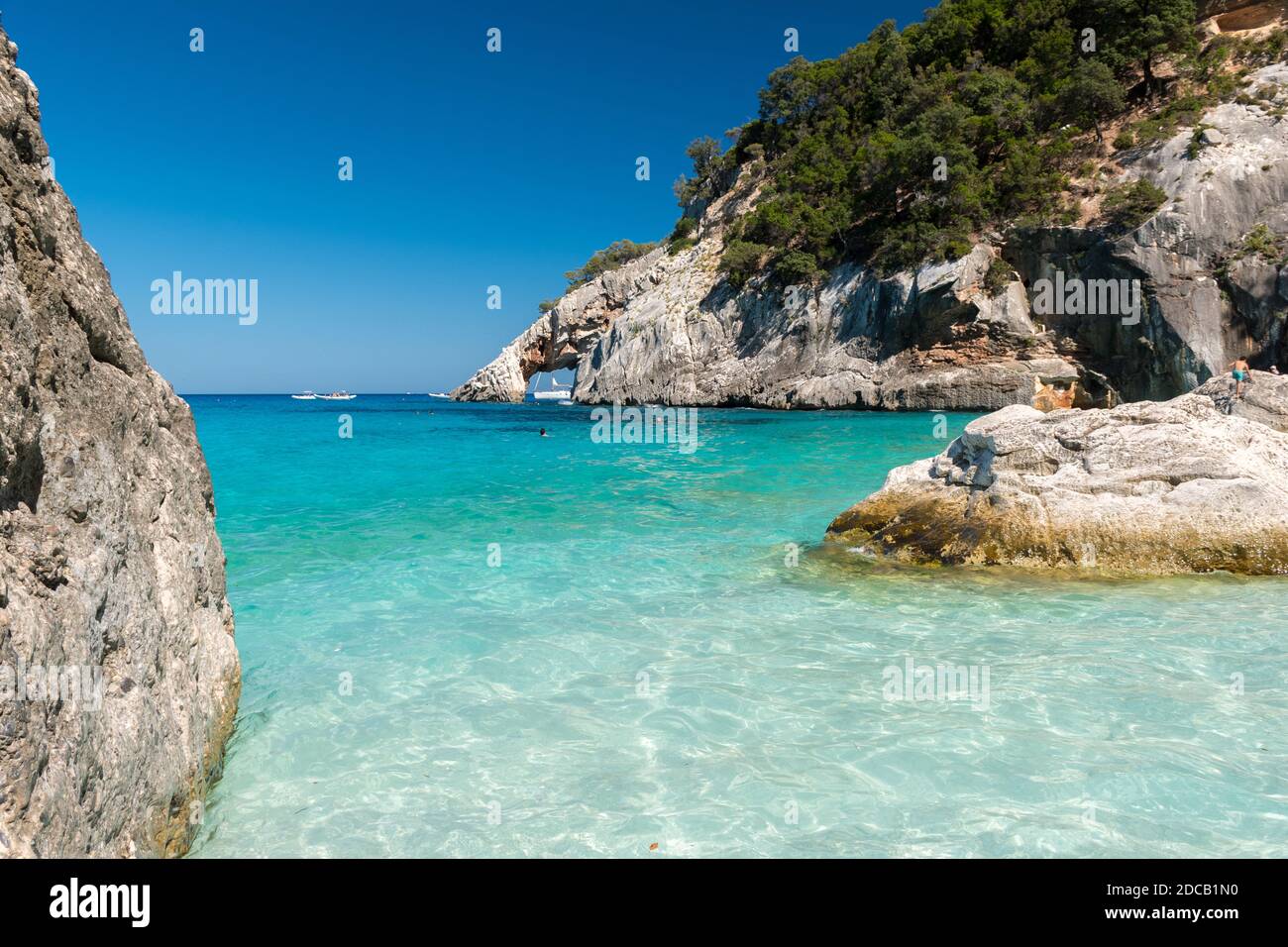 Die Küste in Cala Goloritze, berühmter Strand im Golf von Orosei (Ogliastra, Sardinien, Italien) mit einem natürlichen Bogen im Hintergrund Stockfoto