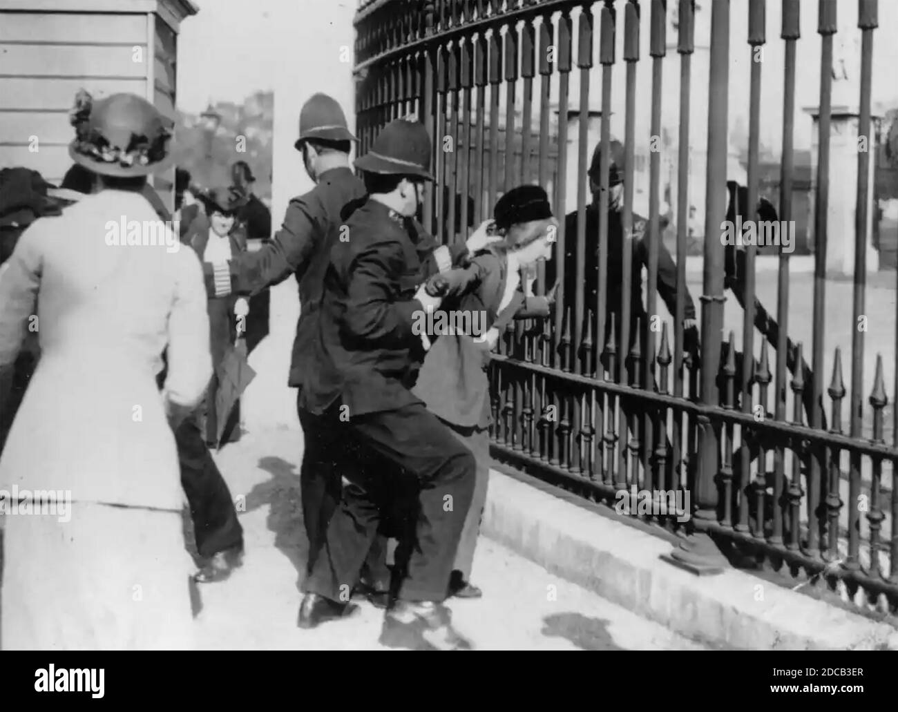 NICHT IDENTIFIZIERTES SUFFRAGETTE versucht, sich an Geländer des Buckingham Palace im Jahr 1914 zu sperren. Stockfoto