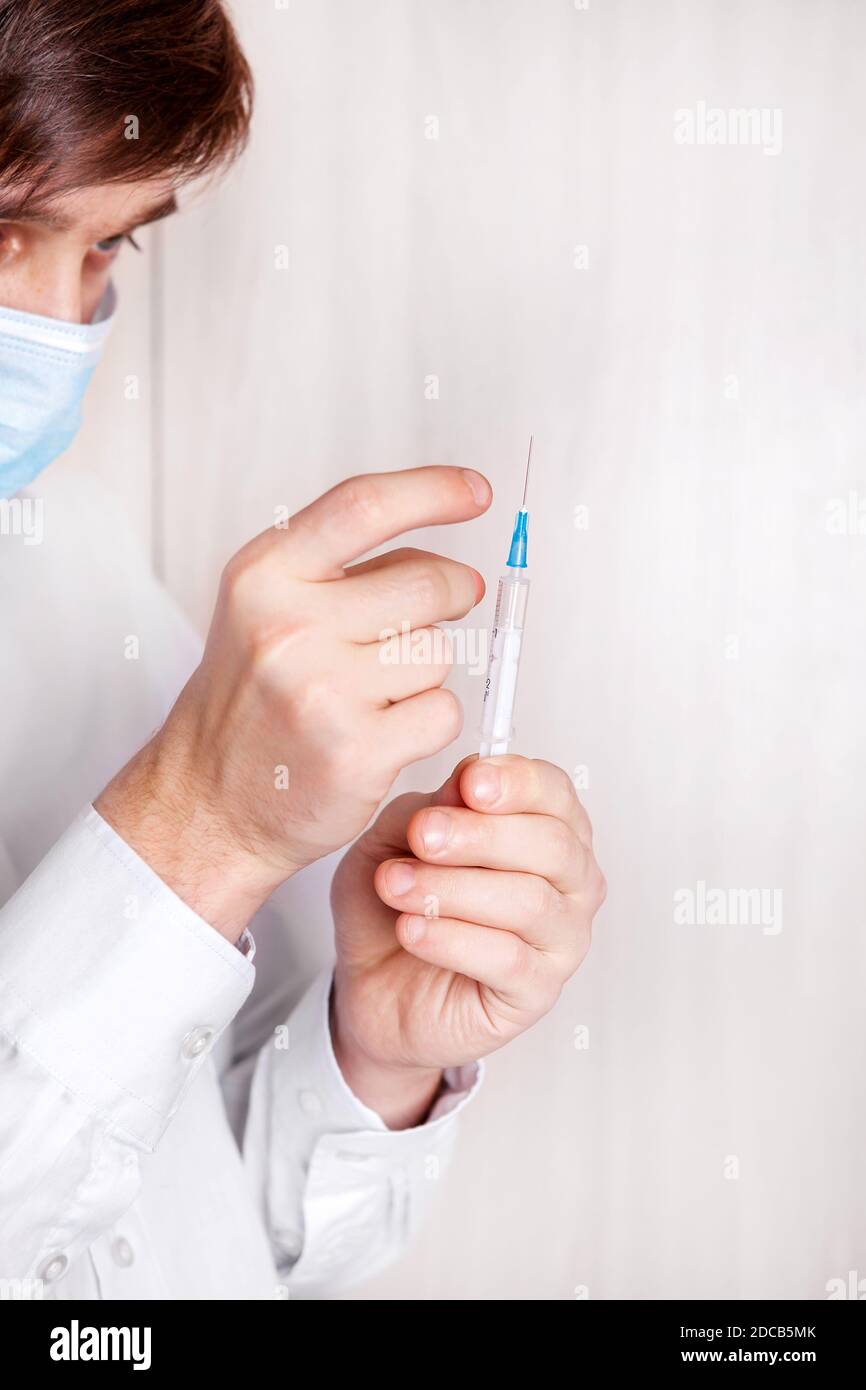 Junger Mann mit einer Spritze an der Wand in der Zimmer Stockfoto