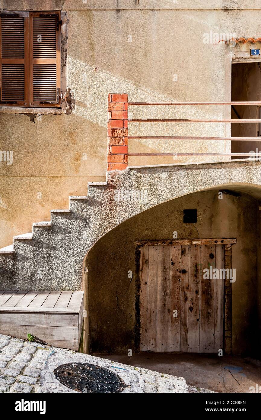 Stufen führen zu einer Tür an der Seite einer alten Villa in Bonifacio Korsika. Stockfoto