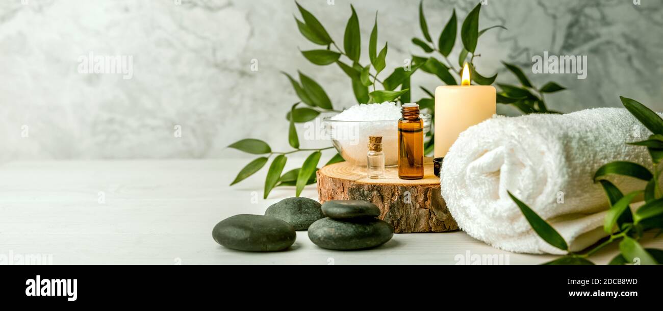 Schönheitsbehandlungen für Spa-Behandlungen auf weißem Holztisch. Massagesteine, ätherische Öle und Meersalz. Kopierraum Stockfoto
