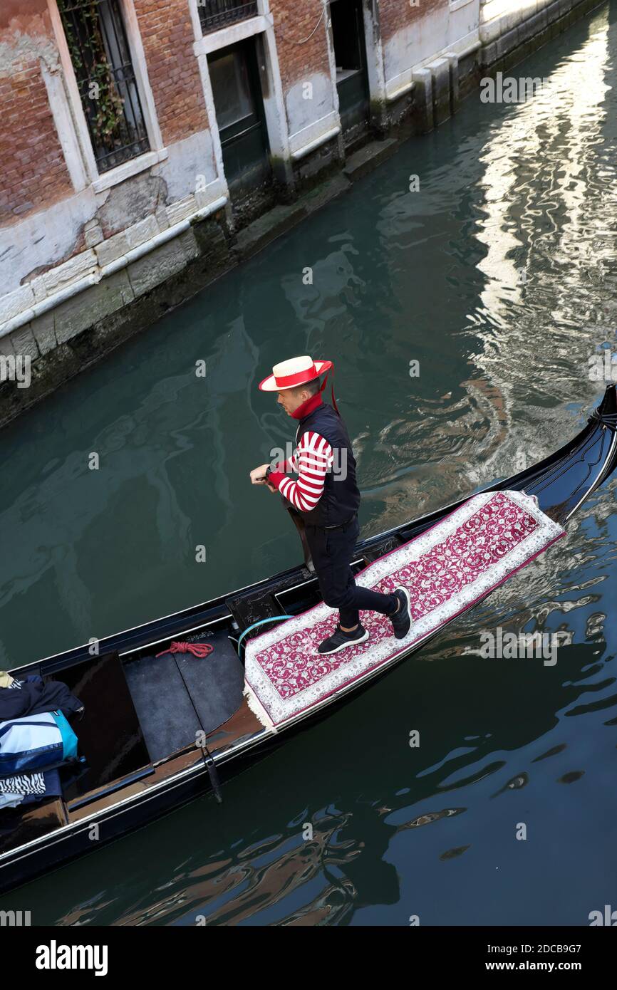 Ein Gondolier und seine Gondel navigieren durch die Kanäle Venedigs Italien Stockfoto