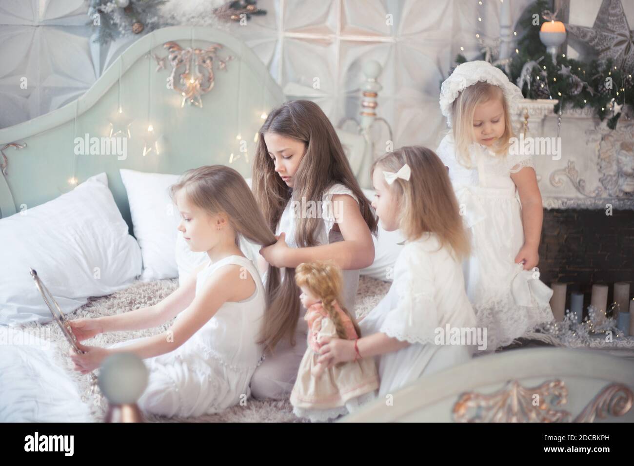 Kleine Mädchen spielen im Schlafzimmer am Morgen vor Weihnachten. Das Konzept der Familie, Schwesternschaft, Freundschaft. Winterferien, Weihnachten, Neujahr. Stockfoto