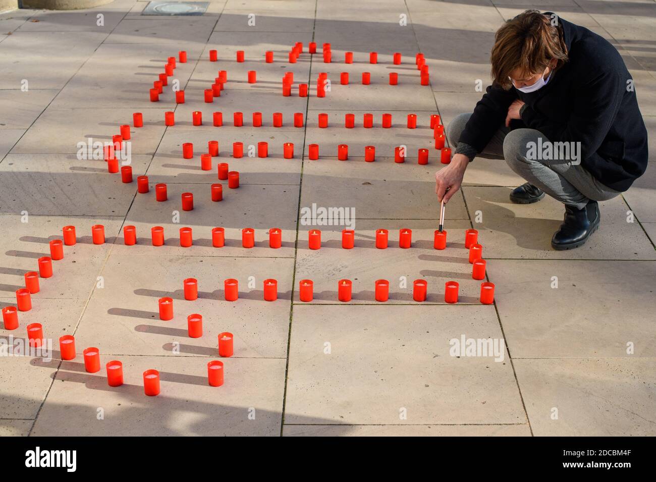 Magdeburg, Deutschland. November 2020. Anke Weinreich von der Staatlichen Intervention und Koordination in häuslicher Gewalt und Stalking Sachsen-Anhalt (LIKO) zündet vor dem landtag vor einer Gedenkveranstaltung zum "Tag gegen Gewalt gegen Frauen", die zusammen die Zahl "117" repräsentieren, Kerzen an. 117 ist die Zahl der Frauen, die 2019 in Deutschland durch partnerschaftliche Gewalt getötet wurden, laut polizeilicher Kriminalitätsstatistik. In Sachsen-Anhalt wurden neun Frauen durch Gewalt in Partnerschaften getötet. Quelle: Klaus-Dietmar Gabbert/dpa-Zentralbild/dpa/Alamy Live News Stockfoto