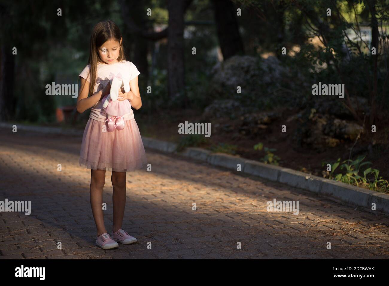 Traurig aufgeregt kaukasischen Mädchen umarmt Spielzeug. Kind umarmen weichen Plüsch Bär im Park im Freien. Verloren einsames Kind Kind draußen. Unglückliche Kindheitsprobleme leben Stockfoto