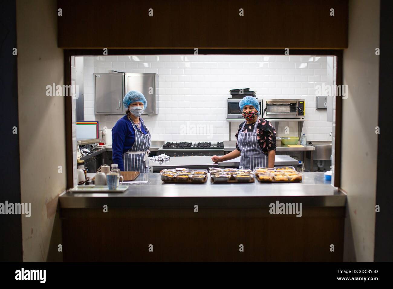 Cradley Heath, West Midlands, Großbritannien. November 2020. Da die Covid-Krise die schwächsten Menschen der Gesellschaft weiterhin betrifft, stellen die Lebensmittelbanken den ärmsten Familien weiterhin dringend benötigte Lebensmittel zur Verfügung. Jeanette Happ und Madhu Frost, Freiwillige in der Holy Trinity Church Foodbank in Cradley Heath, West Midlands, kochen eine Partie Hüttenkuchen, die zum Einfrieren bereit sind. Sie bereiten etwa 30 pro Woche zu geben, um an lokale Familien, die nicht in der Lage sind, ihre eigenen Mahlzeiten zubereiten oder kochen. Kredit: Peter Lopeman/Alamy Live Nachrichten Stockfoto
