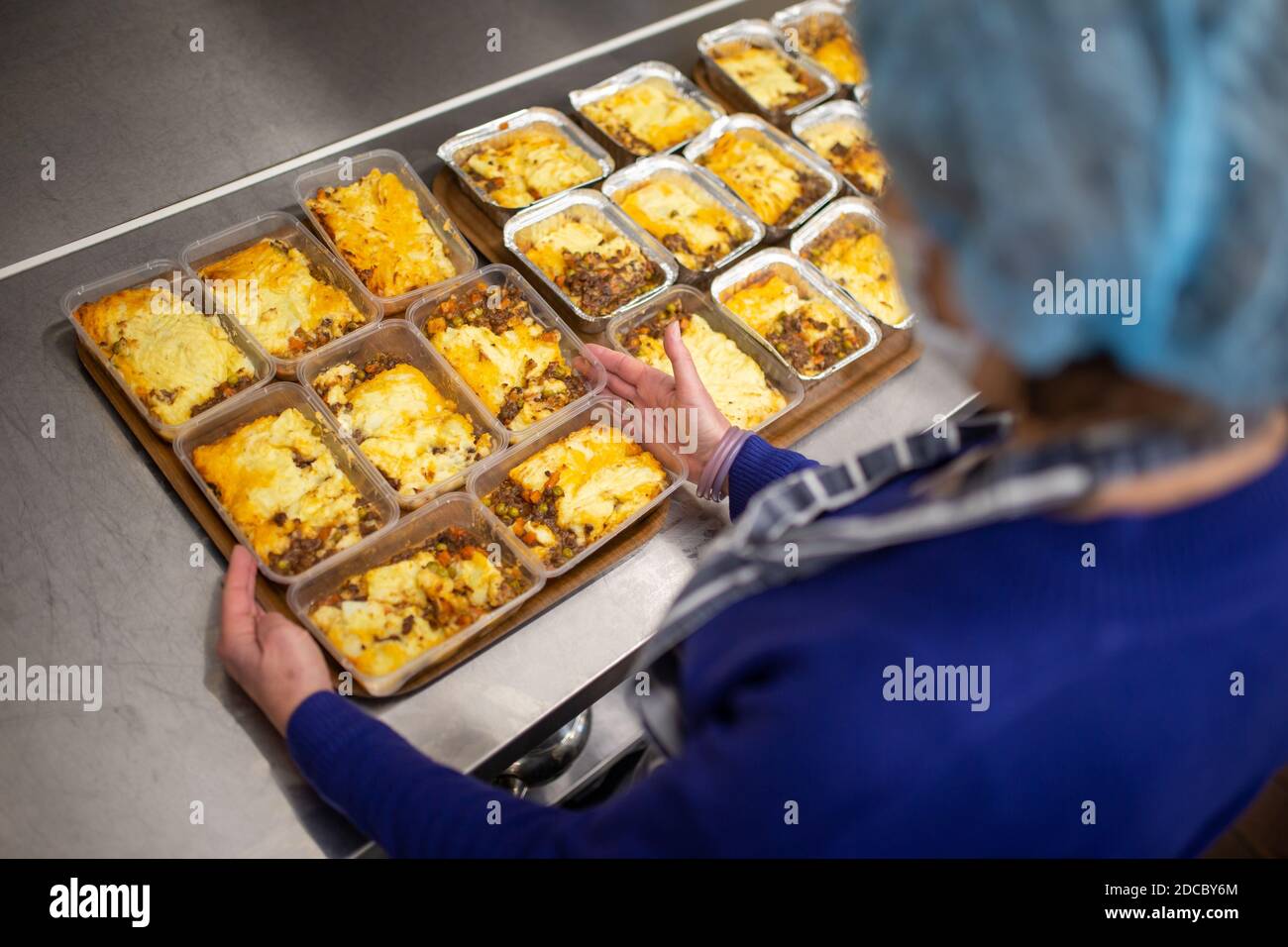 Cradley Heath, West Midlands, Großbritannien. November 2020. Da die Covid-Krise die schwächsten Menschen der Gesellschaft weiterhin betrifft, stellen die Lebensmittelbanken den ärmsten Familien weiterhin dringend benötigte Lebensmittel zur Verfügung. Jeanette Happ, eine Freiwillige an der Holy Trinity Church Foodbank in Cradley Heath, West Midlands, kocht eine Partie Hüttenkuchen, die zum Einfrieren bereit sind. Sie bereiten etwa 30 pro Woche zu geben, um an lokale Familien, die nicht in der Lage sind, ihre eigenen Mahlzeiten zubereiten oder kochen. Kredit: Peter Lopeman/Alamy Live Nachrichten Stockfoto