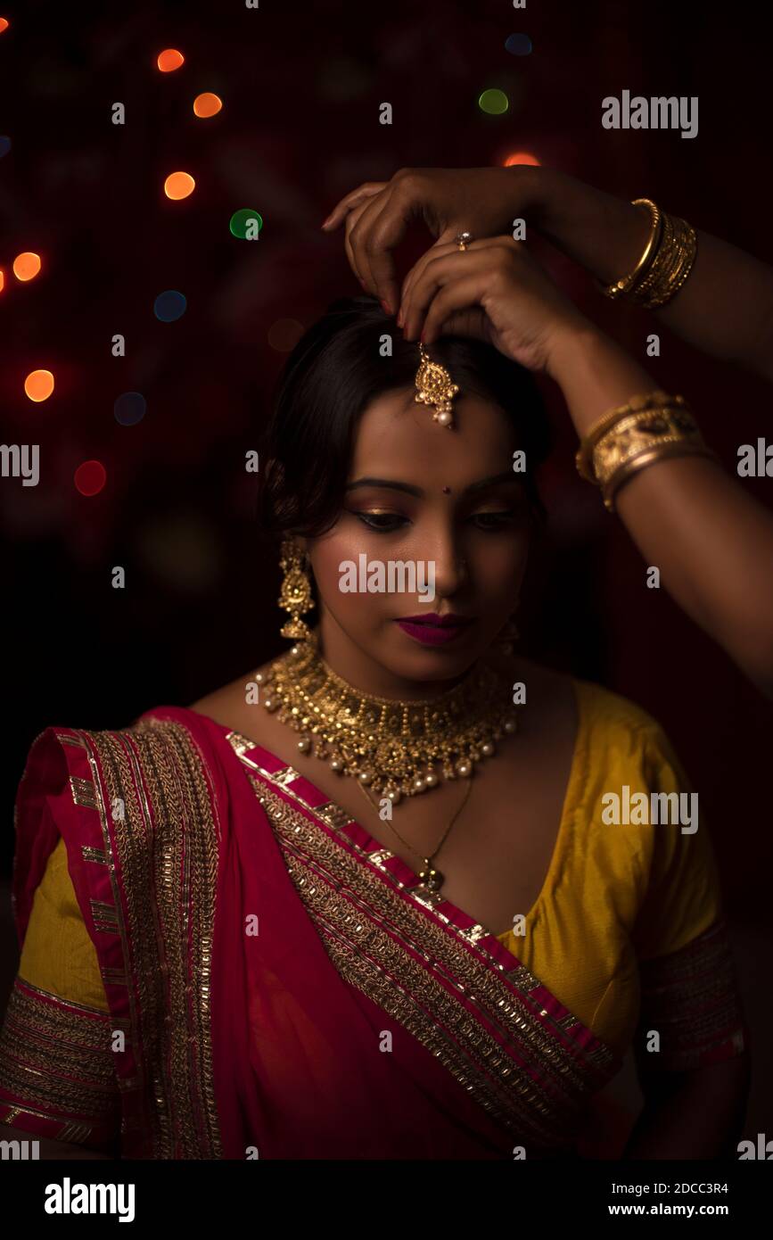 Porträt einer indischen Bengali schöne Brünette Frau vor Von der bunten Licht Bokeh Hintergrund durch winzige Kette erstellt Lichter am Abend von Stockfoto