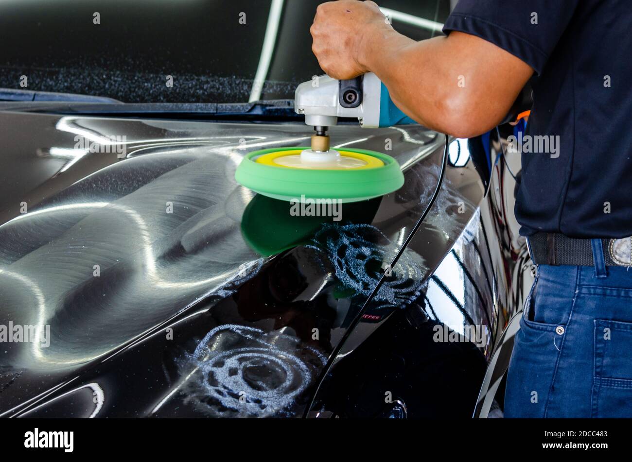 Mann arbeitet für Polieren, Beschichtung Autos. Polieren des Autos wird dazu beitragen, Verunreinigungen auf der Oberfläche des Autos zu beseitigen. Stockfoto