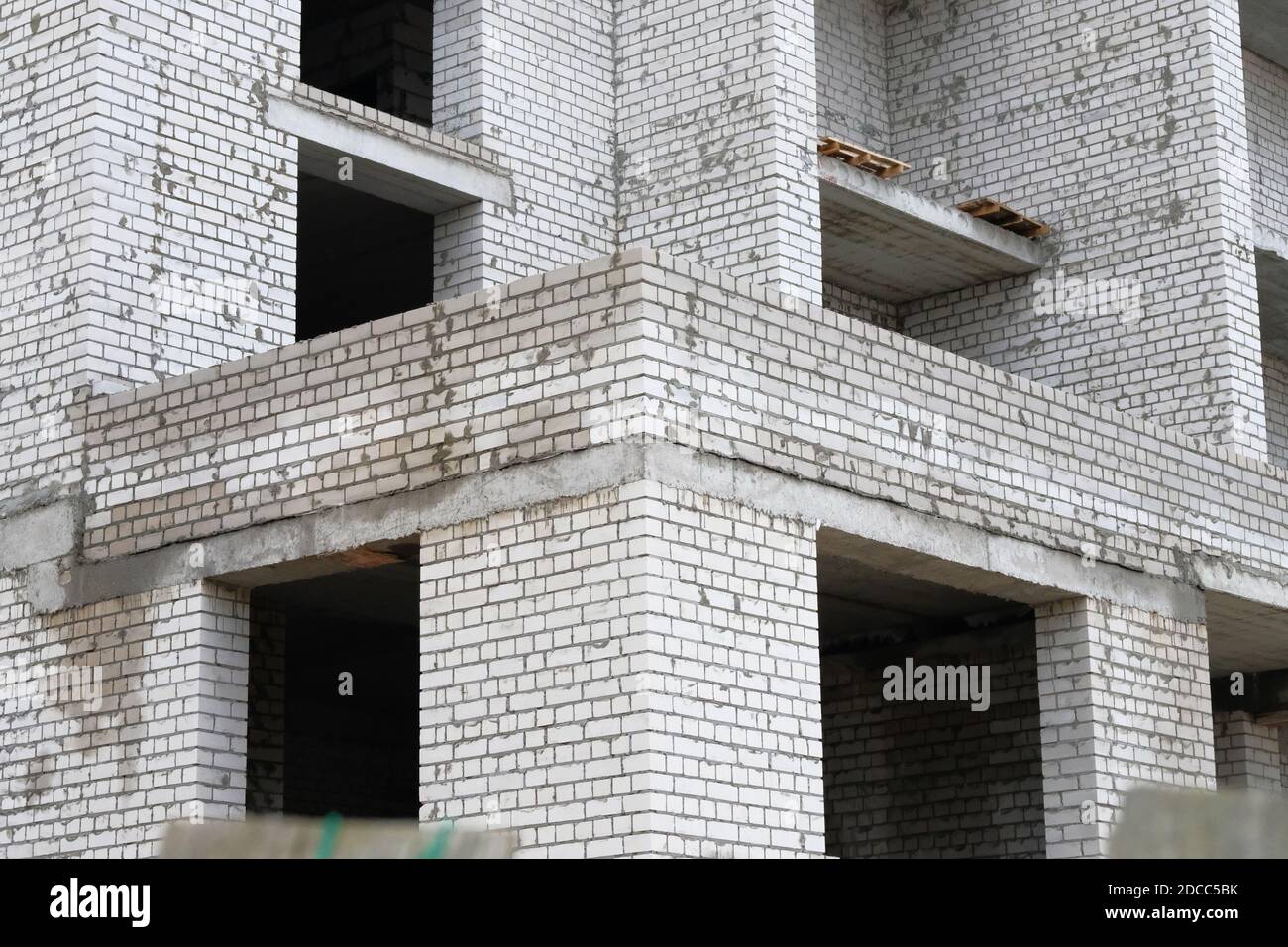 Mehrfamilienhaus aus weißem Backstein im Bau. Baustelle. Baustelle des neuen Hauses. Stockfoto