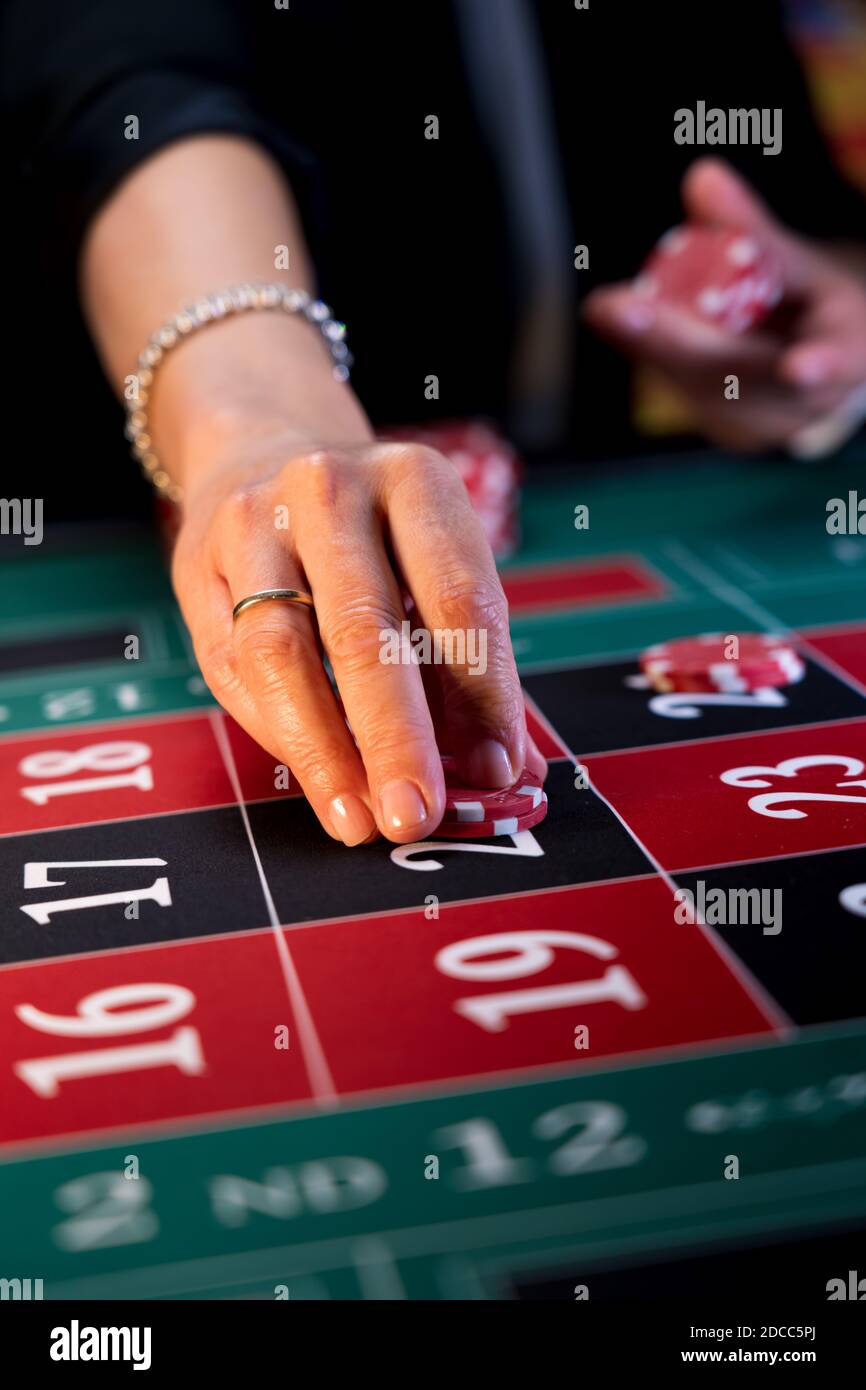 Frau spielt am Roulettetisch im Casino Stockfoto