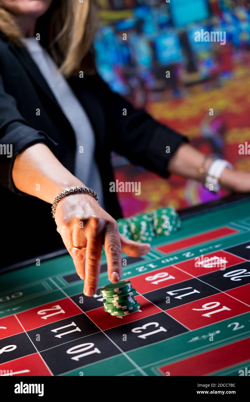 Frau spielt am Roulettetisch im Casino Stockfoto