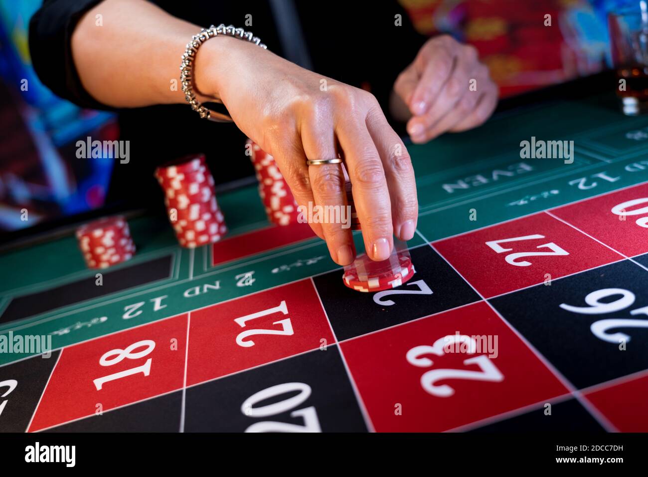Frau spielt am Roulettetisch im Casino Stockfoto