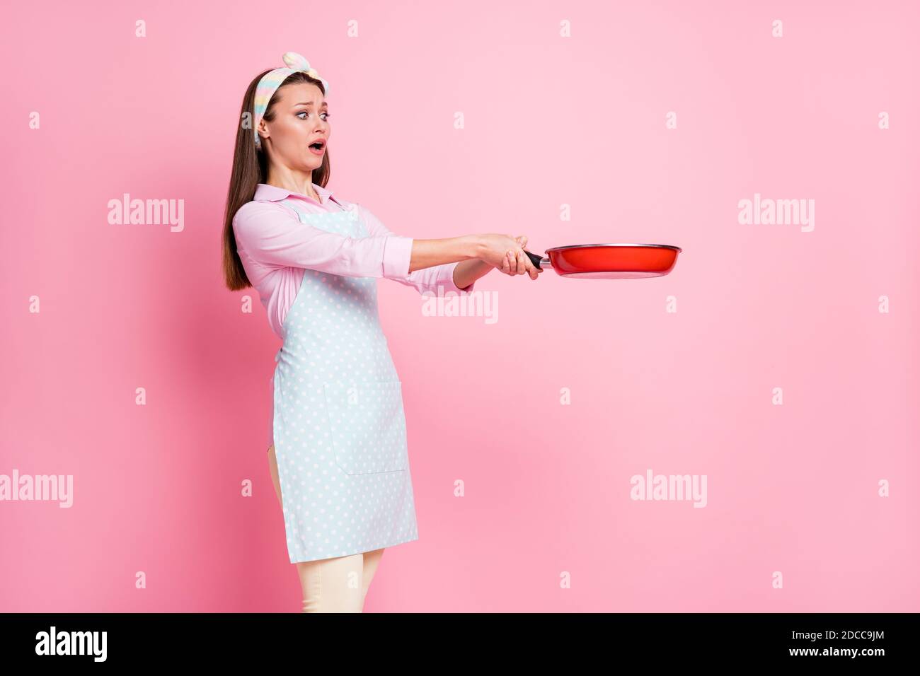 Portrait der Panik ängstlich Mädchen Koch halten Bratpfanne brennen Bio-Essen lecker Abendessen Fail Problem tragen Stil stilvoll trendy hemd in Pastelltönen Stockfoto