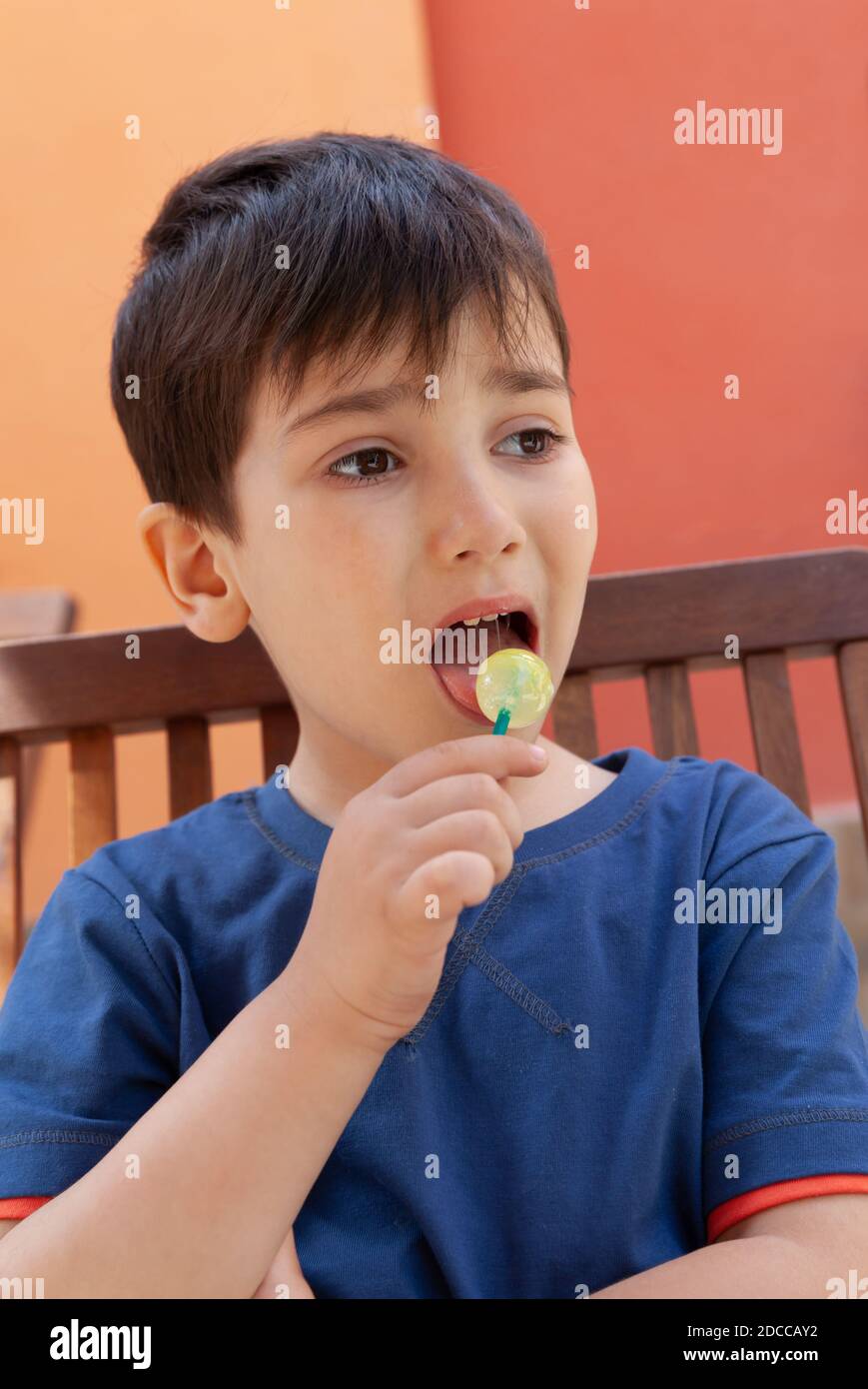 Happy Childhood Konzept. Schneiden Sie kleinen Jungen essen Lollipop Süßigkeiten und Spaß im Freien Stockfoto