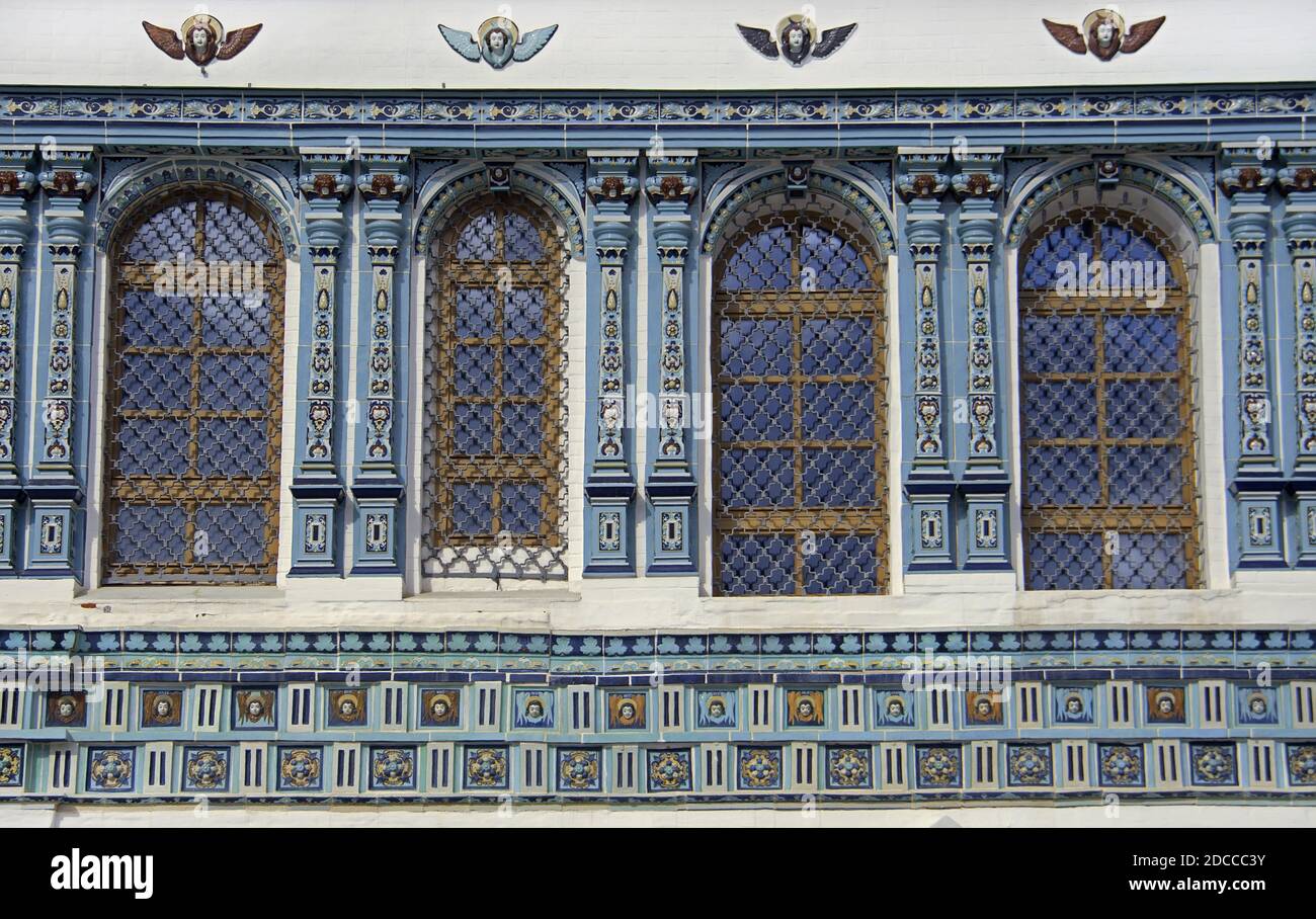 Alte Bogenfenster mit schönen bunten Zierfliesen auf einem Weiße Ziegelmauer der christlichen Kirche Stockfoto