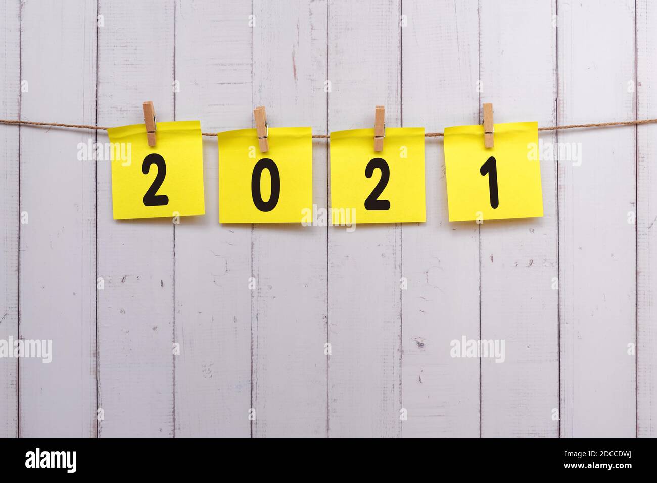 2021 Nummer auf gelbem Papier Notiz hängen mit Wäscheklammer, Holz rustikalen Hintergrund Stockfoto