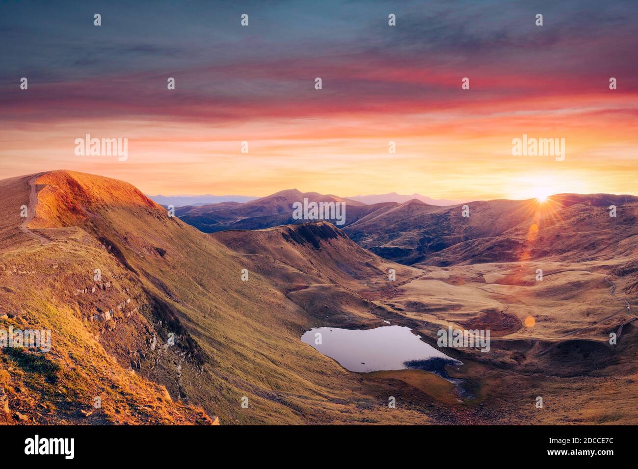 Bergsee bei Sonnenaufgang. Malerische Herbstlandschaft mit Sonne am Morgenhimmel, Karpaten Stockfoto