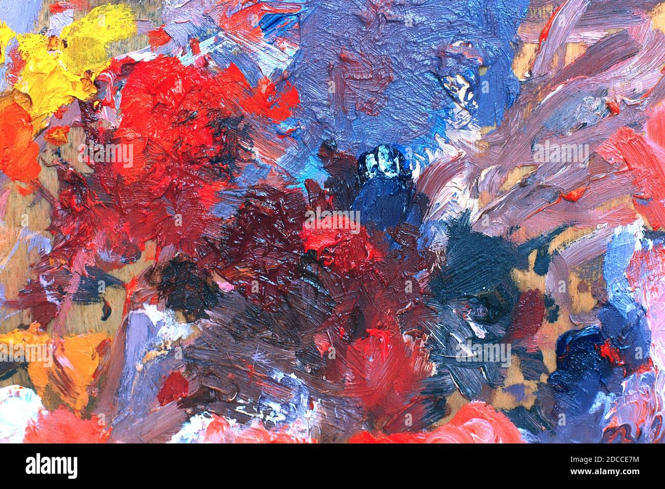 Künstlerpalette mit gemischten Ölfarben. Abstrakter Hintergrund mit bunten Pinselstrichen auf einer Leinwand. Mehrfarbige Hintergrundfarbe Stockfoto
