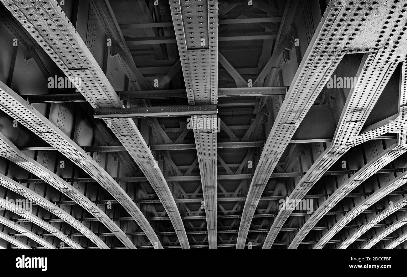 Ein genauer Blick auf die Stahlträger und Träger, die zusammennietet sind, um unter einer Londoner Brücke zu stützen Stockfoto