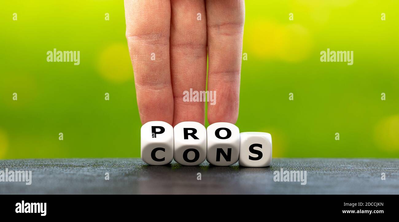 Hand dreht Würfel und ändert den Ausdruck 'cons' in 'pros'. Stockfoto