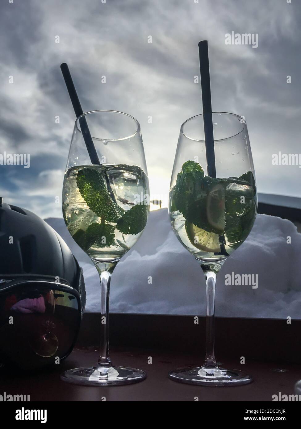 Apres Ski Drinks, zwei Hugo Cocktails mit Holunderblüte und teilweise Ansicht eines Skihelms mit Brille, St.Anton, Österreich Stockfoto