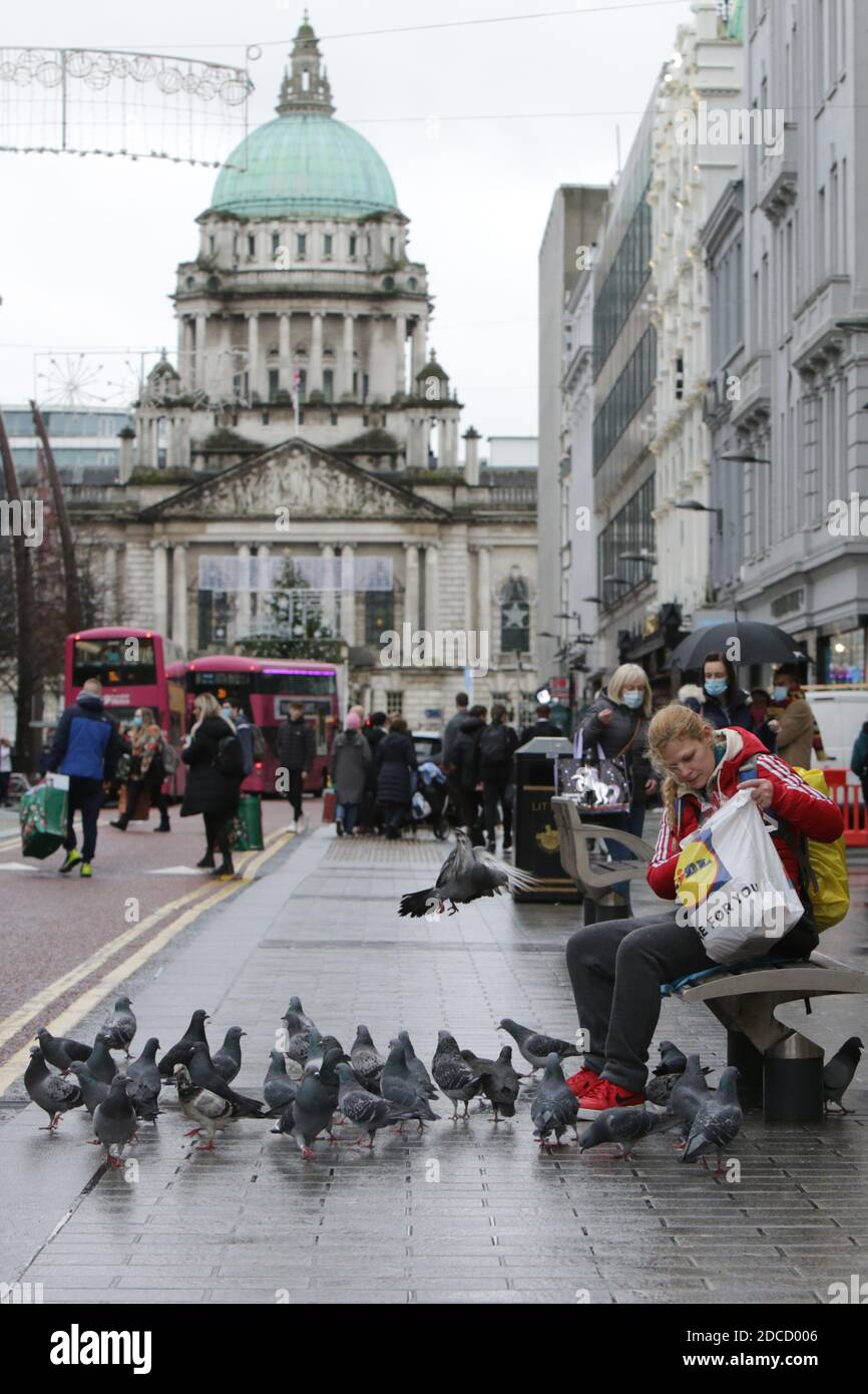 Belfast, Nordirland, Großbritannien. 20 Nov 2020: Ein Mädchen füttert Gebote in der Royal Avenue, während die Käufer zu den Geschäften im Stadtzentrum von Belfast zurückkehren, Freitag, den 20. November 2020. Die nordirische Exekutive hat eine zweiwöchige Sperre angekündigt, die ab November 27 in Kraft treten wird. Während die Schulen weiterhin geöffnet bleiben, können enge Kontakte wie Friseure, Cafés und Close heute wie geplant wieder eröffnet werden, müssen aber nächste Woche wieder geschlossen werden. Kirchen, Fitnessstudios, Freizeitzentren und alle nicht notwendigen Geschäfte werden am 27. November um 12:01 Uhr für zwei Wochen geschlossen. Kredit: Irish Eye/Alamy Live Nachrichten Stockfoto